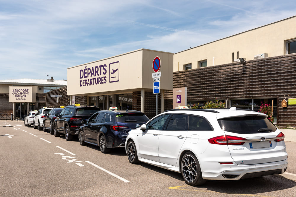 Plusieurs taxis de Taxi Carcassonne garés devant l'aéroport